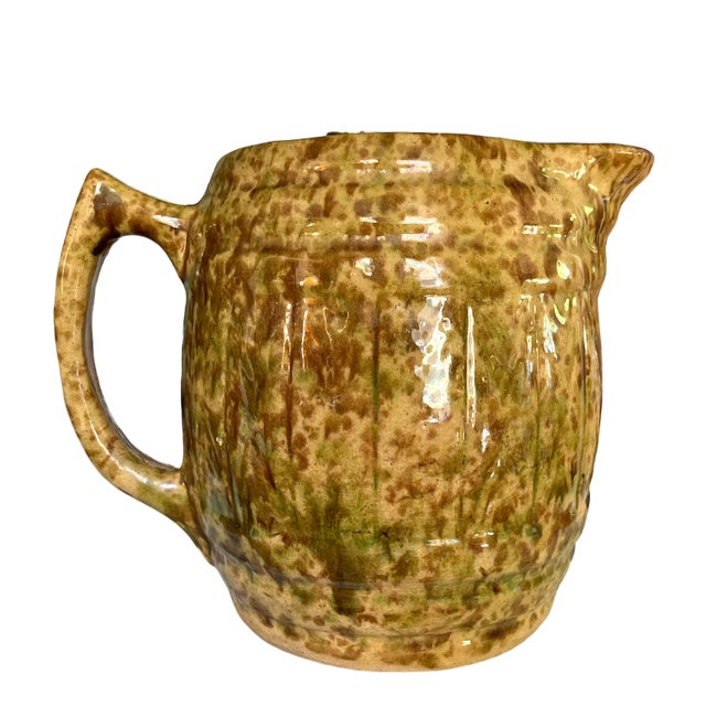 Antique earthtone splatterware pitcher with 3 quarts (2.8 liters) capacity. Yellow-tan body hand splattered with brown and...
