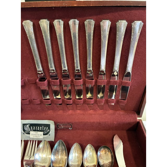 Vintage 1881 Rogers silverplate flatware set housed in the original burgundy-lined wooden storage chest. This elegant...