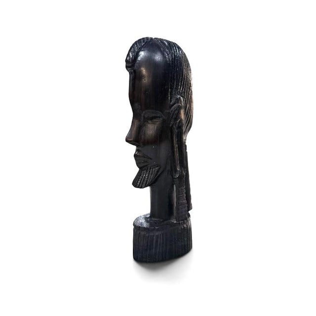 Hand carved wooden head sculpture produced during the mid-20th century. the sculpture is executed in dark stained wood and...