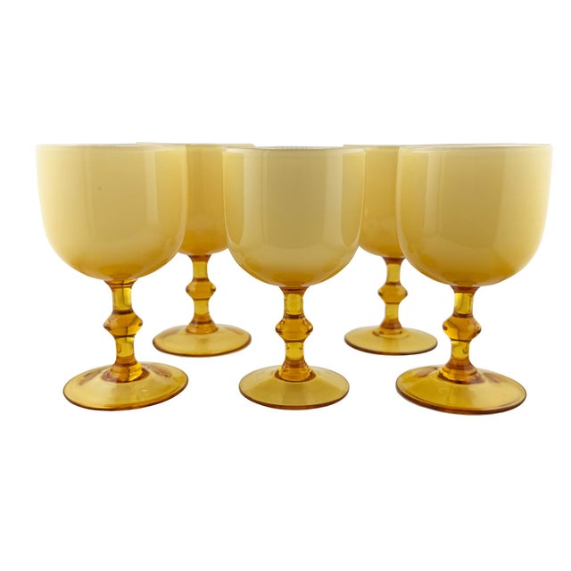 An elegant set of five hand-blown Italian stemmed goblets featuring luminous cased opaline glass bowls paired with rich...