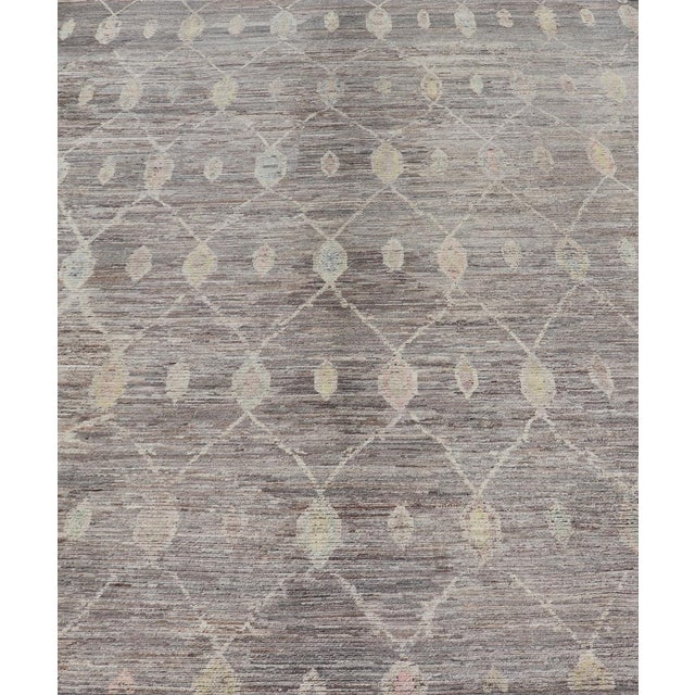 Measures: 13'6 x 19'5. This modern casual tribal rug has been hand-knotted. The rug features a modern sub-geometric...