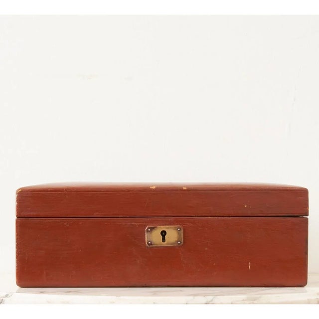 A French painted leather jewelry box with an inset brass handle, personalized for “EU, January, 24, 1898”. Inside you’ll...