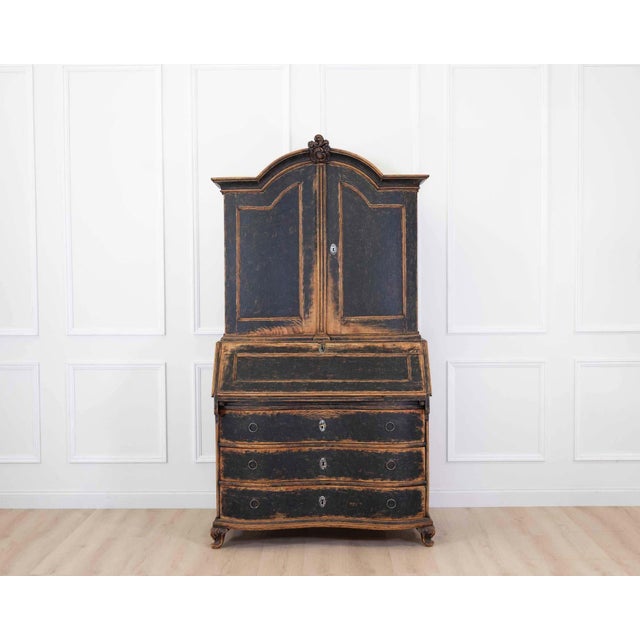 Made in Denmark in the eighteenth century, this bow-fronted rococo secretary has been repainted in black with a blue...
