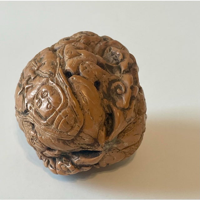Highly detailed carved Chinese walnut shell. The figural and floral carvings are represented on each side. Circa late...