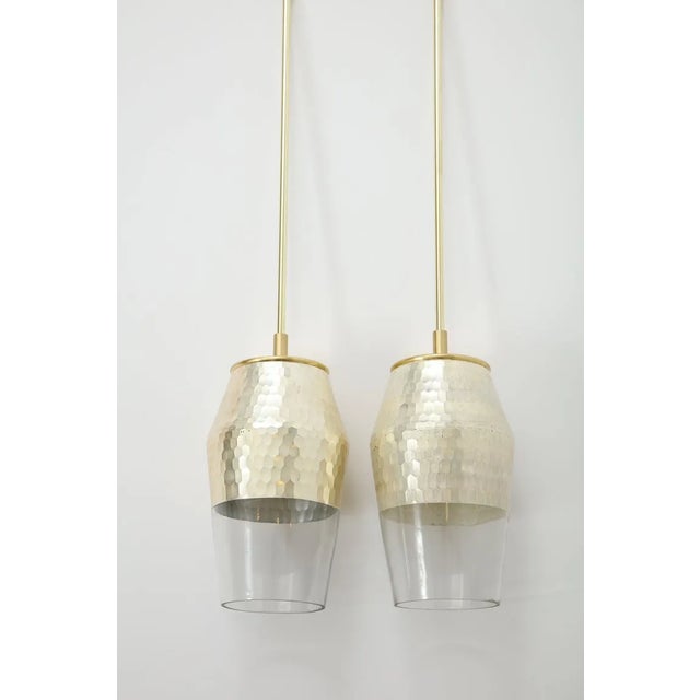 Pair of vintage pendant lights with a honeycomb textured finish and a glazed silver leaf interior. The polished brass...