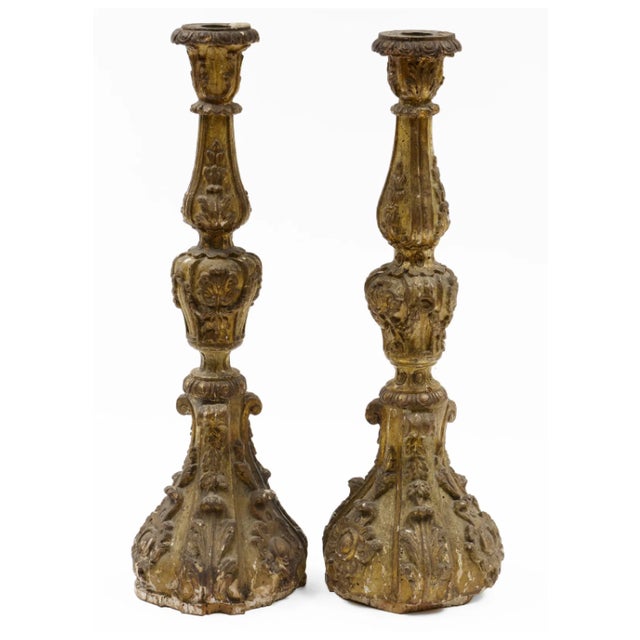 An exquisite pair of monumental Italian Baroque giltwood candlesticks, featuring richly carved architectural forms,...