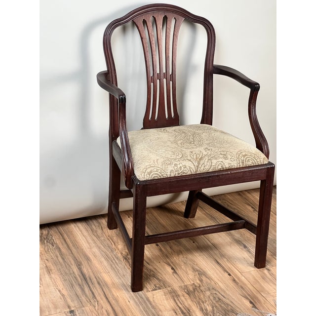 Elegant in both form and proportion, this antique English George III armchair dates to the early 19th century and reflects...