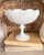 An elegant white pedestal compote bowl with scalloped edges and draped relief detail. This unmarked piece has a timeless...