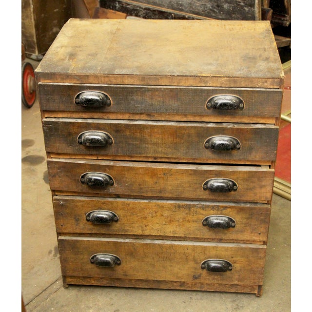 Industrial style workshop chest of drawers made of wood and steel bin pulls. It features five drawers, one with a divider....