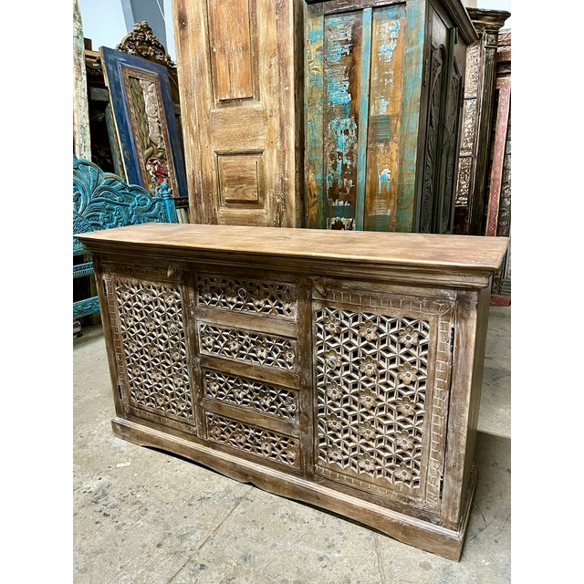 Add timeless bohemian character to your space with this beautifully carved wooden sideboard, finished in a soft natural...