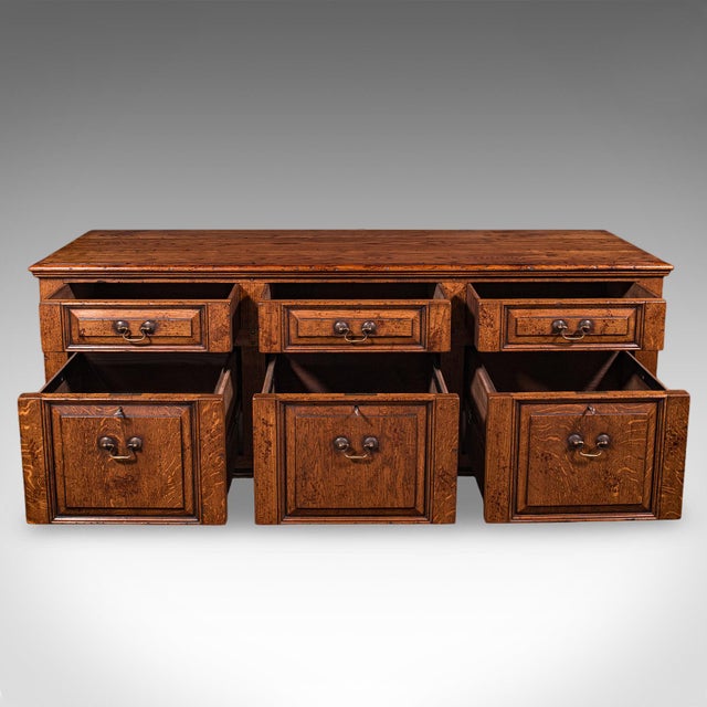 This is a large vintage country house dresser base. An English, oak storage cabinet in Georgian revival taste, dating to...