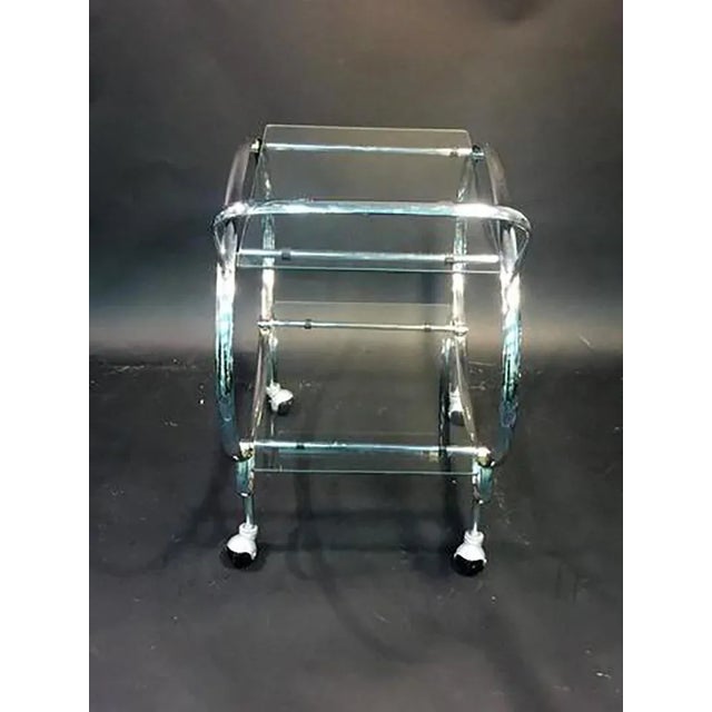 Modernist Art Deco design tubular chrome form double tier glass shelved bar cart on caster wheels. Simple but elegant...
