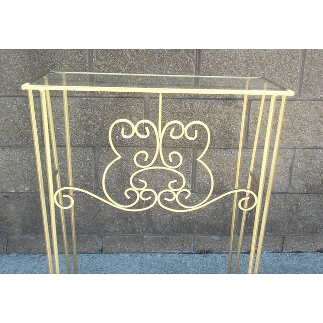 A Petite Mid-Century era gilded iron hall table with scrolled detail and clear glass top. With the scroll facing out, this...