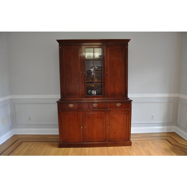 A traditional style cabinet with flame mahogany and bubble glass breakfront custom made in Argentina, circa 1989. The...