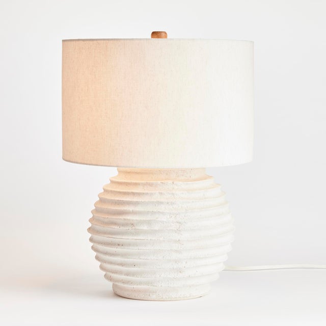 A ceramic base designed with handmade horizontal ribbing, this lamp is made with an artisan feel. Topped off with a linen...
