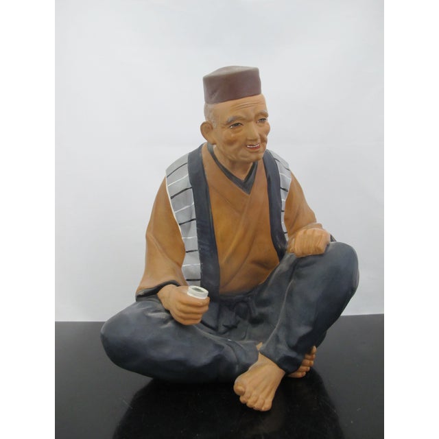 Vintage Japanese Hakata Urasaki clay doll figurine of an old man drinking tea. Collectible Japanese statue dating from the...