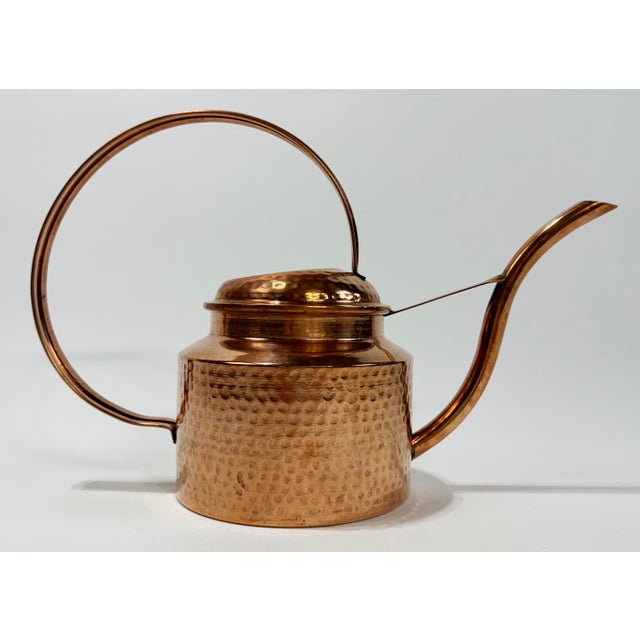 Vintage sculptural hammered copper watering can with a rounded body and prominent handle and spout. Lovely patina.