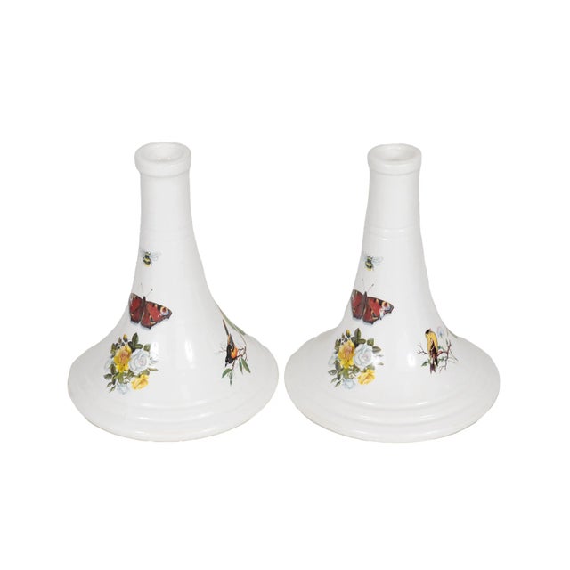 A pair of Italian ceramic candlestick holders made by Ethan Allen. White conical shaped holders are decorated with...