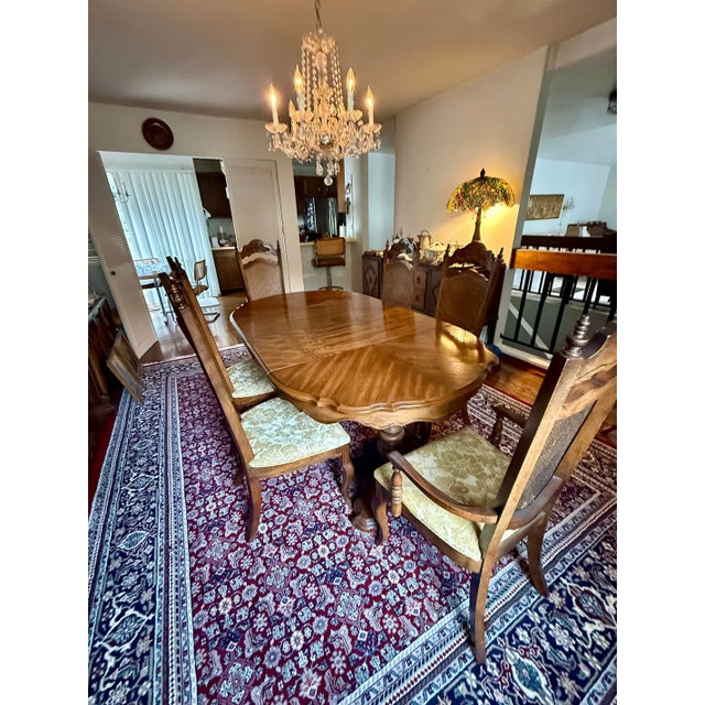 A beautiful French Provincial oak dining set featuring a scalloped-edge extension table and six matching high-back cane...