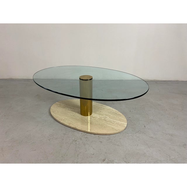 A simple yet stunning oval travertine, brass, and glass coffee table by Leon Rosen for Pace. The glass is nestled between...