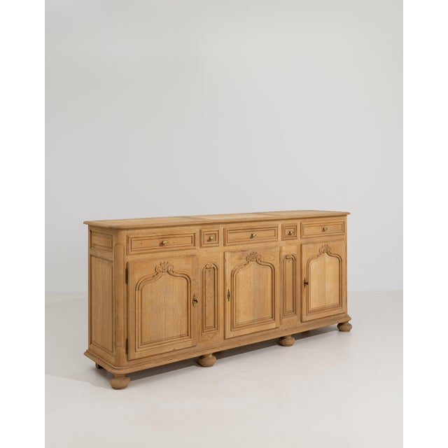 A Louis XIV style oak buffet produced in France in the 1970s. The piece features heavy proportions, paneled construction,...