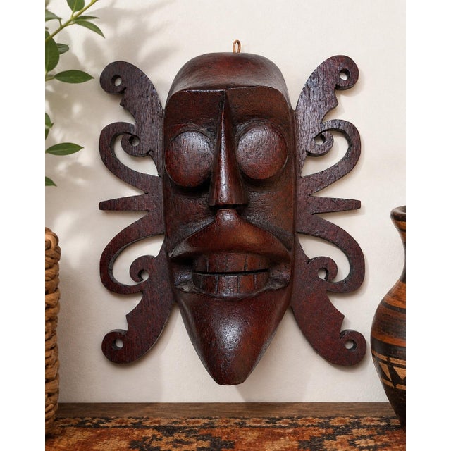 A wonderfully sculptural vintage Indonesian hand-carved wood wall mask inspired by the traditional artistic vocabulary of...