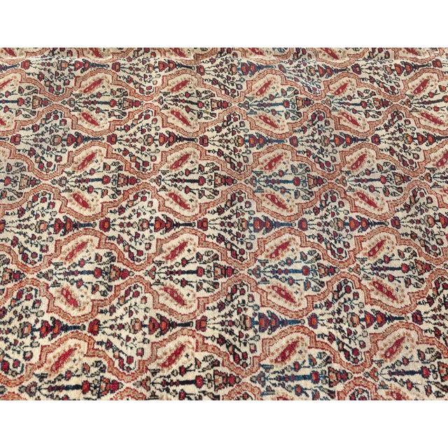 This circa-1880 antique Persian Kerman carpet features a strikingly detailed all-over design of floral abstractions and...