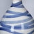 Swirling stripes of blue add artistry and elegance to a contemporary ceramic table lamp. Sitting atop a crystal disc base,...