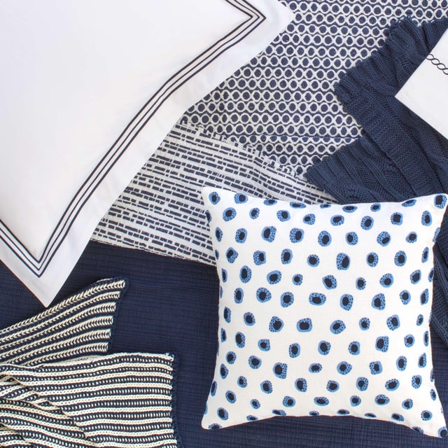 Featuring a modern circle graphic on one side and a dashed line print on the other, this reversible cotton quilt in a deep...