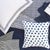 Featuring a modern circle graphic on one side and a dashed line print on the other, this reversible cotton quilt in a deep...