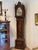A George III tall case clock with a dark ground chinoiserie-decorated case — figures, pagodas, and flowering trees in gold...