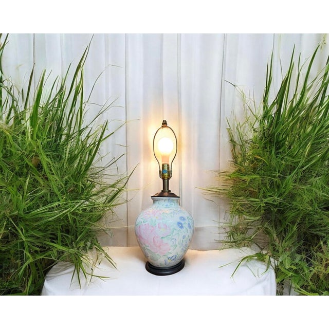 Offering a vintage Chinosserie ceramic hand-painted floral table lamp. Ceramic ginger jar with a black wood base and...