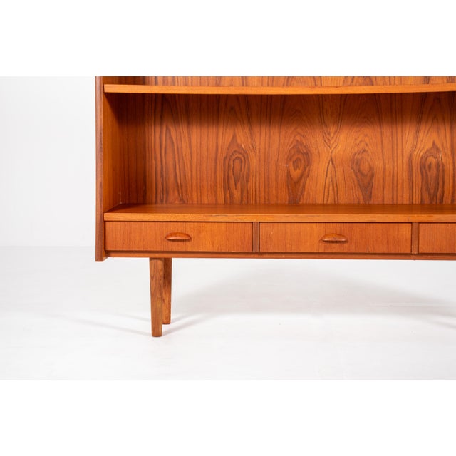 Beautiful vintage mid century bookcase made in warm teak veneer. The cabinet has a clean Scandinavian design with simple...