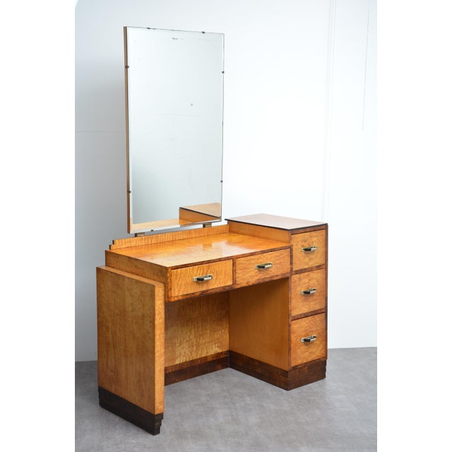 An exceptional and highly architectural english art deco dressing table, having an original bevelled edge mirror with some...