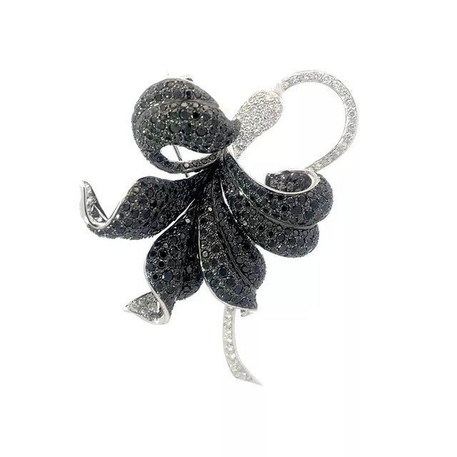 This eye-catching beautiful brooch is crafted from 17k white gold featuring a long-curved white gold stem and flower...