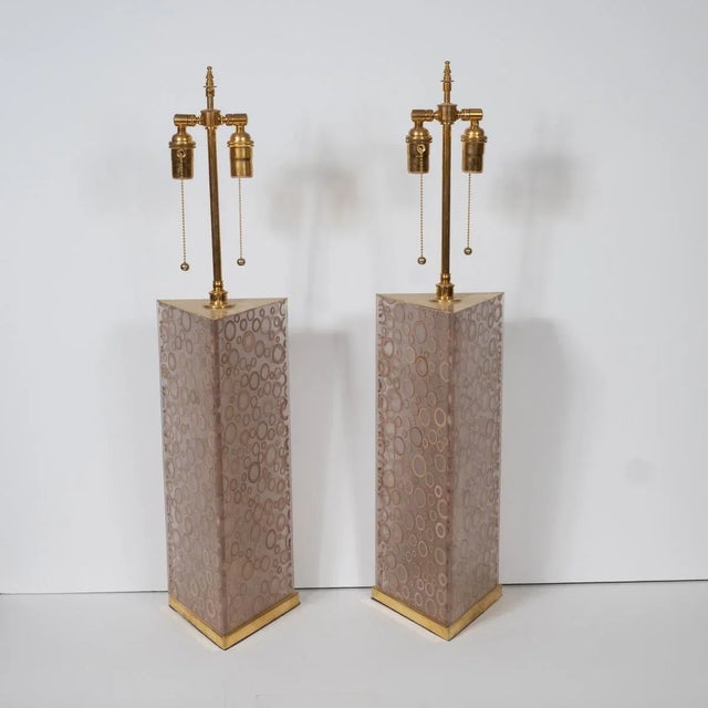 Pair of smoked acrylic lamps with ring motif and brass hardware.