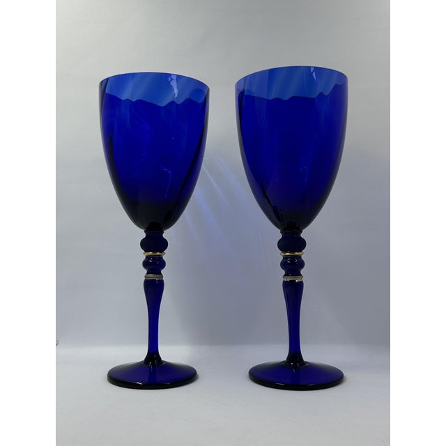 Striking pair of vintage cobalt blue art glass goblets featuring richly saturated bowls with a subtle optical swirl effect...