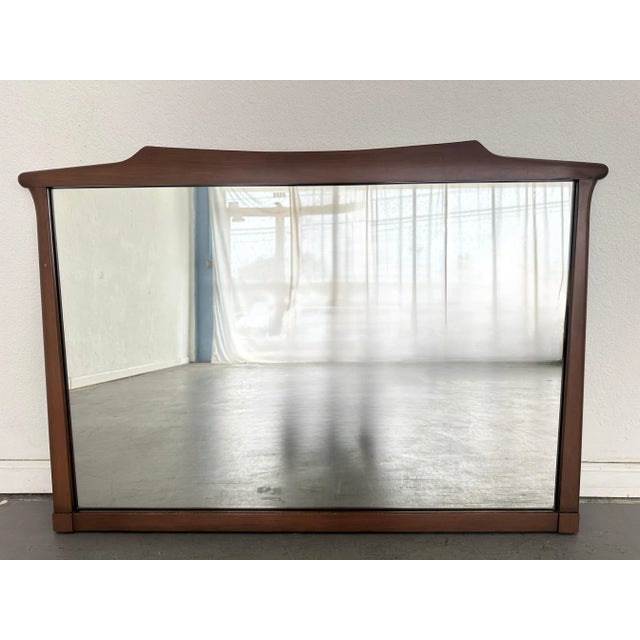 A vintage wall mirror made by White Pine Furniture in the 1970s. This piece features a solid wood frame with sculptural...