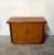Vintage mid-century modern dry bar featuring warm honey-toned wood veneer, flowing grain, and layered molding with gently...