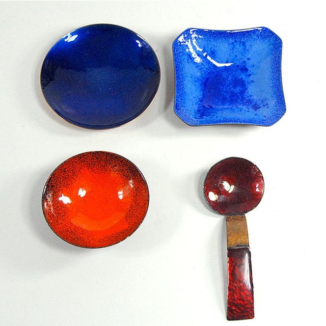 A highly decorative set of small copper vessels decorated with colorful enamel. The set includes two round platters, one...