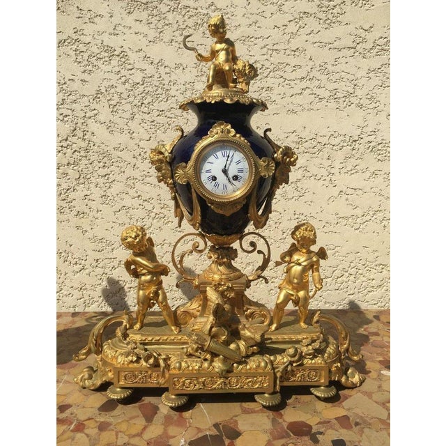 Imposing and magnificent fireplace gilded bronze and blue porcelain vases. The clock is decorated with putti representing...