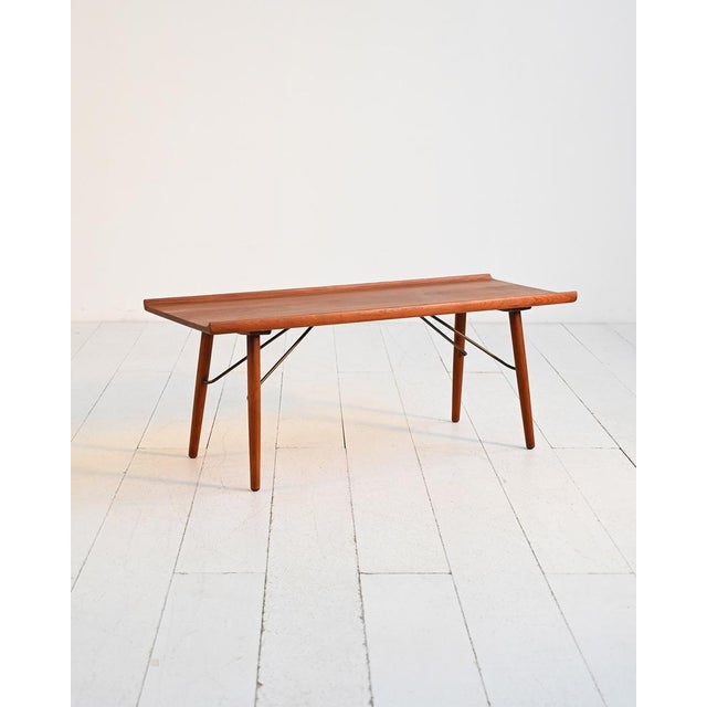 Solid teak coffee table with shaped edges and brass tie rods. Attributed to Børge Mogensen for Søborg Møbler, 1950s....