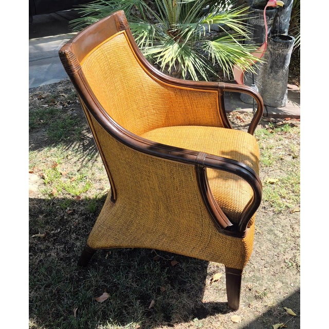 This is a Hollywood Regency or British Colonial style woven rattan wingback armchair. Structural and Design Highlights...