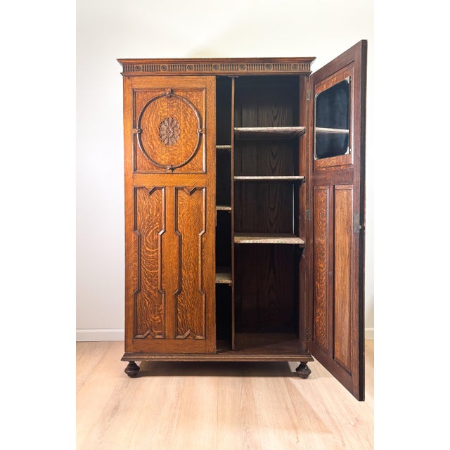Bring a touch of stately English heritage to your home with this magnificent Tudor Revival style oak wardrobe. Crafted in...