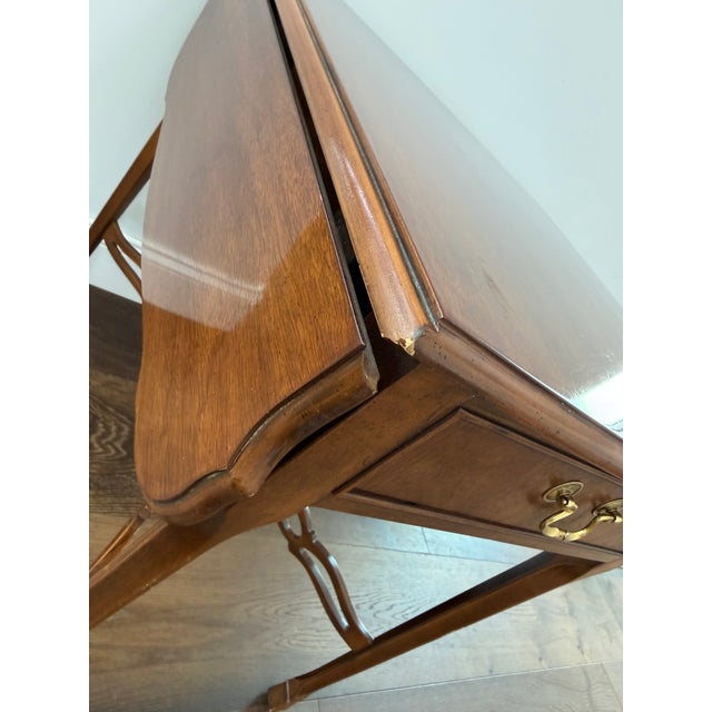 This vintage gateleg table by Drexel features a beautifully finished mahogany wood top with two drop leaves, a single...