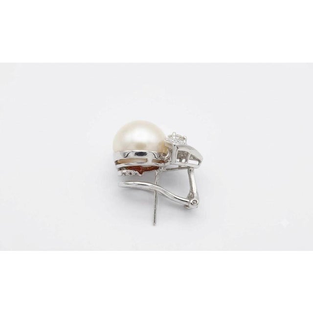 Luxurious 18K white gold earrings featuring luminous 13.1mm South Sea pearls accented by 3.25 carats total weight of round...