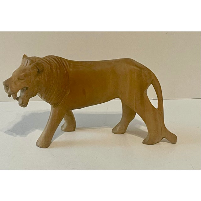 Detailed olive wood Lion sculpture from Kenya, by the Kamba tribe. The vintage carving measures about 5” tall x 8” long x 3”.