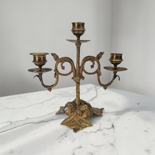 Antique three-light candelabrum executed in gilt metal and dating from the Art Nouveau period, circa 1900–1930. The design...