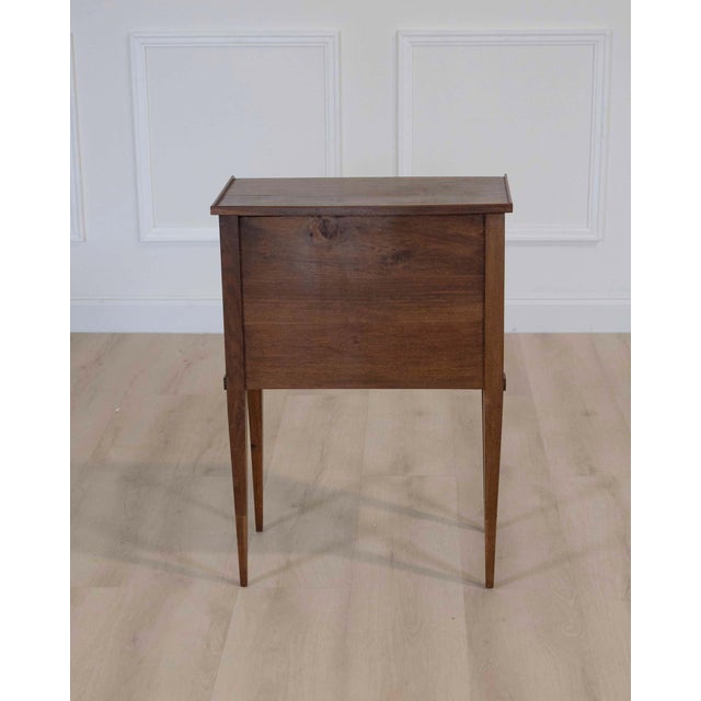 Made in France in the twentieth century, this Louis XVI style bedside or side table is constructed in walnut and opens at...