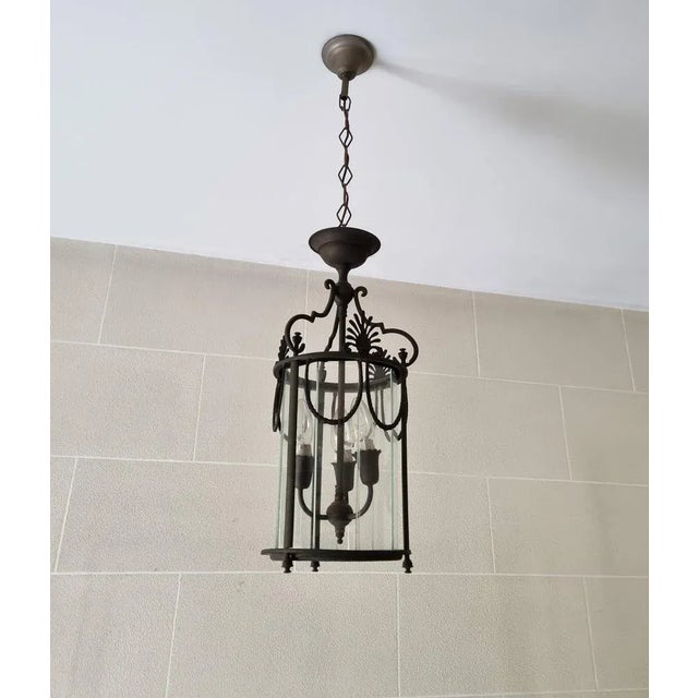 Antique Neoclassical style lantern of bronze and paneled glass. Around 1900 Inside three candle lamps This lantern has...